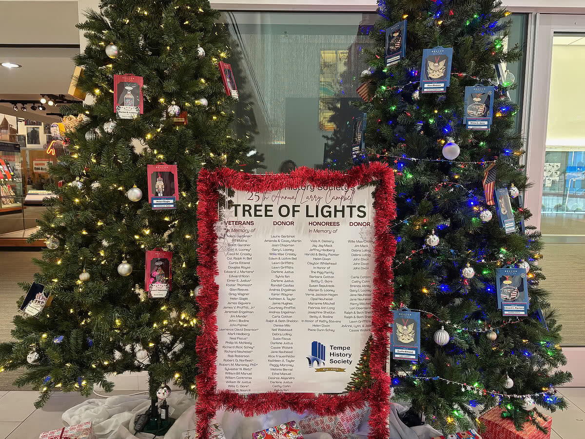 The two 2025 Christmas Trees showing the Tree of Lights ornaments and poster of honorees.